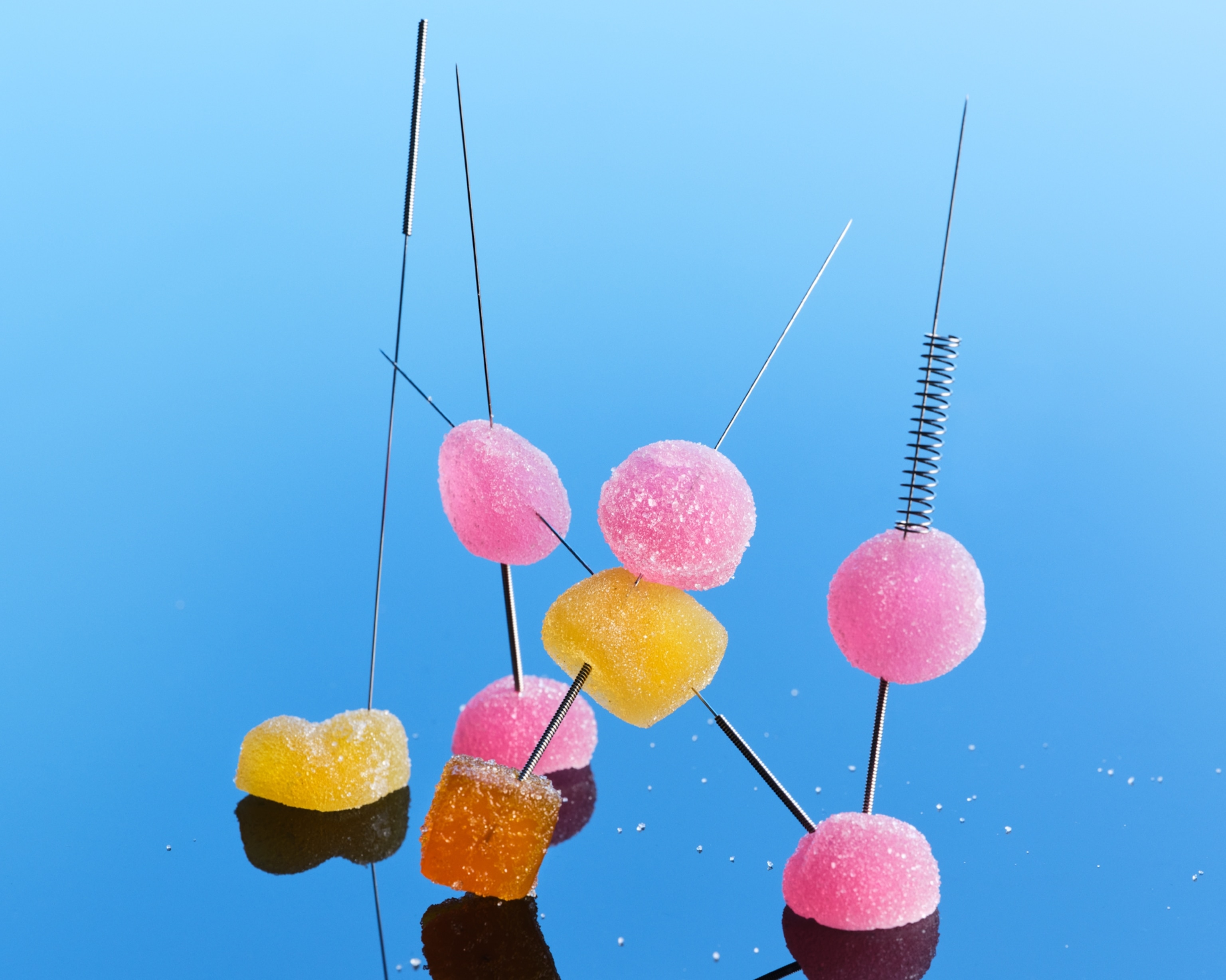 Colorful gummies on metal spears.